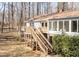 Rear exterior showcasing the deck, stairs, sunroom, and well-maintained yard at 6021 Dickson Mill Rd, Durham, NC 27705