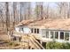 Rear exterior showcasing the deck, stairs, sunroom, and skylights at 6021 Dickson Mill Rd, Durham, NC 27705