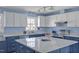 Modern kitchen featuring white cabinets, blue island, granite countertops, and stainless steel appliances at 6021 Dickson Mill Rd, Durham, NC 27705