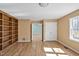 Open living room with hardwood floors, built-in bookshelves, and natural light from the windows at 6021 Dickson Mill Rd, Durham, NC 27705