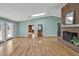 Spacious living room with a brick fireplace, hardwood floors, and a view of the outdoor deck at 6021 Dickson Mill Rd, Durham, NC 27705