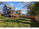Expansive backyard view featuring a well-manicured lawn, a wooden fence, and a charming screened-in porch at 608 Dowd St, Durham, NC 27701