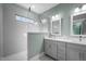 Modern bathroom featuring a tiled shower, window, dual sink vanity, and mint green accents at 608 Dowd St, Durham, NC 27701