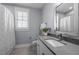 Bathroom with a sink vanity, toilet, shower curtain, and window with shutters at 608 Dowd St, Durham, NC 27701