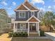 Charming two-story home features a welcoming front porch, beautiful landscaping, and a mix of siding and wood accents at 608 Dowd St, Durham, NC 27701