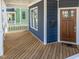 Inviting front porch featuring wood flooring, a white railing, and a charming entrance door with a 'HOME' welcome mat at 608 Dowd St, Durham, NC 27701