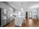 Spacious kitchen with stainless steel appliances, a central island with seating, and modern pendant lighting at 608 Dowd St, Durham, NC 27701