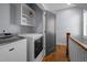 Well-equipped laundry room with modern appliances, storage shelves, and access to the upper level at 608 Dowd St, Durham, NC 27701
