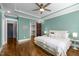 Spacious primary bedroom with a tray ceiling, hardwood floors, and a sliding barn door to the walk-in closet at 608 Dowd St, Durham, NC 27701