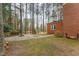 Brick home featuring a large backyard and patio area surrounded by trees at 636 Palmer Dr, Sanford, NC 27330