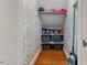 Walk-in closet featuring floral wallpaper, wood floors, and ample shelving at 636 Palmer Dr, Sanford, NC 27330