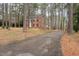 Classic two-story brick house with black shutters nestled in a wooded lot at 636 Palmer Dr, Sanford, NC 27330