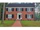 Charming brick two-story home featuring black shutters, brick walkway and decorative patriotic bunting at 636 Palmer Dr, Sanford, NC 27330