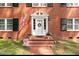 Close-up of a classic brick home's entryway, showcasing a decorated white door with a wreath at 636 Palmer Dr, Sanford, NC 27330