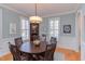 Inviting dining room with a round wood table, plantation shutters, and classic wainscoting at 705 Highgrove Dr, Chapel Hill, NC 27516