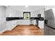 A modern kitchen with stainless steel appliances, white cabinets, subway tile backsplash, and hardwood floors at 707 Memorial Ave, Dunn, NC 28334