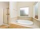 Relaxing bathroom featuring a soaking tub, separate shower, and frosted windows for privacy at 708 Pitchback Mill Ct Ct, Wake Forest, NC 27587