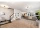Spacious living room with plush carpeting, a staircase, and seamless transition to the dining area at 708 Pitchback Mill Ct Ct, Wake Forest, NC 27587