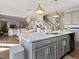 Open kitchen with an island featuring a sink, bar seating, quartz countertop, and open view to the living room at 724 Bracklyn Ave, Zebulon, NC 27597