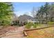 This house features a backyard with a wooden path, gravel and mature trees, creating a nature filled landscape at 7805 Fairlake Dr, Wake Forest, NC 27587