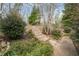 This home includes a backyard with professionally landscaped yard with stone and wood chip path and mature trees at 7805 Fairlake Dr, Wake Forest, NC 27587
