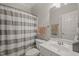Well-lit bathroom featuring a shower with a striped curtain and white fixtures at 7805 Fairlake Dr, Wake Forest, NC 27587