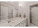 Bright bathroom with double vanity, large mirror, sconce lighting, and door to water closet at 7805 Fairlake Dr, Wake Forest, NC 27587