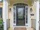 Inviting front door with glass detailing, sidelights, sconces, and a 'Welcome' mat enhancing curb appeal at 7805 Fairlake Dr, Wake Forest, NC 27587
