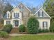 Charming two-story home with yellow siding, black shutters, and lush landscaping at 7805 Fairlake Dr, Wake Forest, NC 27587