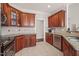 Well lit kitchen featuring wood cabinets, tile floors, granite counters, and stainless steel appliances at 7805 Fairlake Dr, Wake Forest, NC 27587