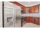 Bright kitchen featuring stainless steel refrigerator, granite counters, tile backsplash, and wood cabinets at 7805 Fairlake Dr, Wake Forest, NC 27587