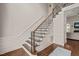 Elegant staircase with dark wood treads, decorative iron railings, and wainscoting at 7805 Fairlake Dr, Wake Forest, NC 27587