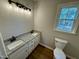 Bathroom featuring double sink vanity with granite countertop and modern lighting at 100 N 6Th St, Erwin, NC 28339