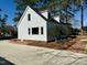 Side view of a two-story home with a brick patio, manicured landscaping, and a long driveway at 100 N 6Th St, Erwin, NC 28339