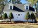 Close up of a cozy two-story home featuring dormer windows, a brick entryway, and tidy landscaping at 100 N 6Th St, Erwin, NC 28339