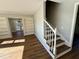 Open-concept living room featuring wood floors, built-in bookshelves, and a staircase at 100 N 6Th St, Erwin, NC 28339