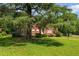 Charming brick home with a large tree and lush lawn offers classic curb appeal with an American flag flying at 1000 S 9Th St, Lillington, NC 27546