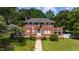 Charming two-story red brick home with landscaped yard and walkway, complemented by an American flag at 1000 S 9Th St, Lillington, NC 27546