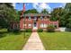Charming two-story red brick home with landscaped yard and walkway, complemented by an American flag at 1000 S 9Th St, Lillington, NC 27546