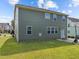 Backyard view of home includes large grassy area, sliding door, and basketball hoop at 1021 Traditions Meadow Dr, Wake Forest, NC 27587