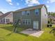 Backyard view of home includes large grassy area, sliding door, and basketball hoop at 1021 Traditions Meadow Dr, Wake Forest, NC 27587