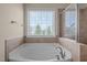 Bathroom with a large tub and a view of the outdoors at 1021 Traditions Meadow Dr, Wake Forest, NC 27587