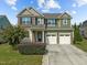 Two-story home with two-car garage, brick and siding exterior, and landscaped front yard at 1021 Traditions Meadow Dr, Wake Forest, NC 27587