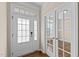 Inviting foyer with glass paneled front door, sidelights, and french doors and hardwood flooring at 1021 Traditions Meadow Dr, Wake Forest, NC 27587