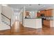 Open-concept living room features hardwood floors, staircase, view of kitchen and entry way at 1021 Traditions Meadow Dr, Wake Forest, NC 27587