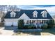 Charming single-Gathering home featuring a manicured lawn, two-car garage, and inviting front porch with American flag at 105 Glasgow Dr, Clayton, NC 27520