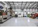 View of the spacious garage with white walls, ample storage, and a tractor for projects at 105 Glasgow Dr, Clayton, NC 27520