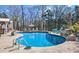 An in-ground pool with a patio featuring lounge chairs and a decorative rock waterfall at 105 Glasgow Dr, Clayton, NC 27520