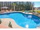 An in-ground pool with a patio featuring lounge chairs and a decorative rock waterfall at 105 Glasgow Dr, Clayton, NC 27520