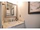 Chic powder room featuring a granite countertop, a sink, and coastal-inspired decor at 105 Glasgow Dr, Clayton, NC 27520